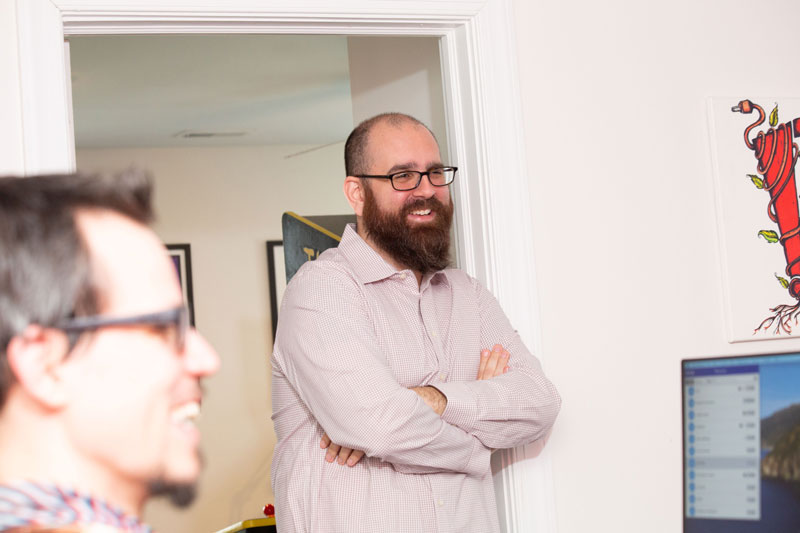 Neil leaning on wall in office